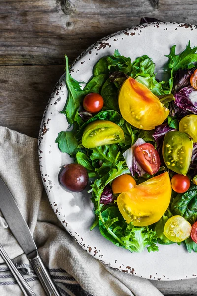 Salada fresca com espinafre, arugula e tomate de herança em rústico — Fotografia de Stock