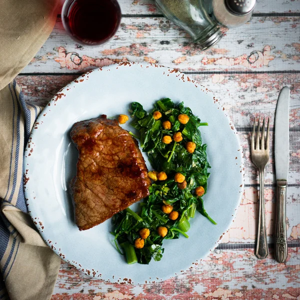 Fresh steak with green salad on rustic wooden background — Stock Photo, Image