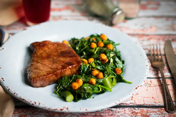 Fresh steak with green salad on rustic wooden background — Stock Photo, Image