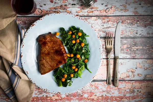 Steak frais avec salade verte sur fond bois rustique — Photo