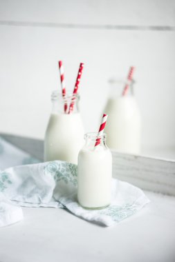 Beyaz ahşap zemin üzerinde kırmızı şeritli payet ile süt kavanoz