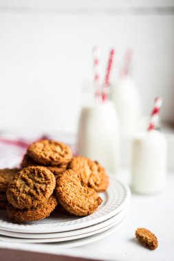 Beyaz ahşap zemin üzerinde kavanozlara Sütlü yulaf ezmeli kurabiye