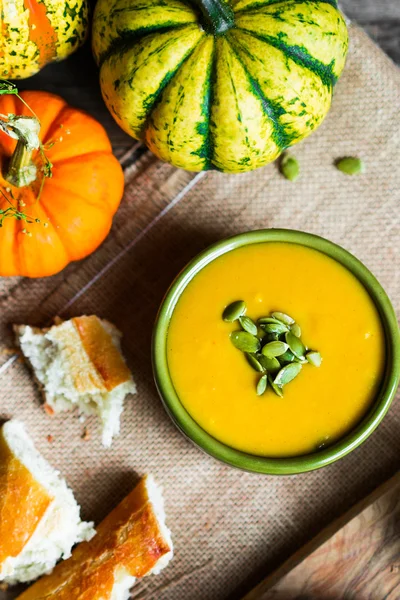 Sopa de calabaza cremosa con semillas sobre fondo de madera —  Fotos de Stock