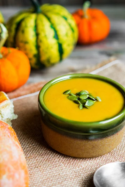 Sopa de calabaza cremosa con semillas sobre fondo de madera —  Fotos de Stock