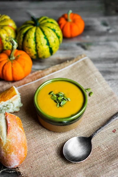 Sopa de calabaza cremosa con semillas sobre fondo de madera —  Fotos de Stock