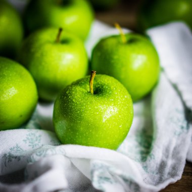 Ahşap arka plan üzerinde parlak yeşil elma