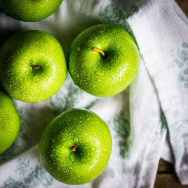 Ahşap arka plan üzerinde parlak yeşil elma