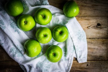 Ahşap arka plan üzerinde parlak yeşil elma