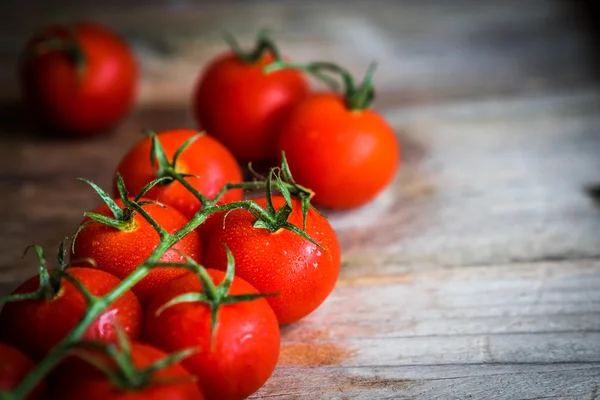 Tomates sobre fondo rústico de madera — Foto de Stock