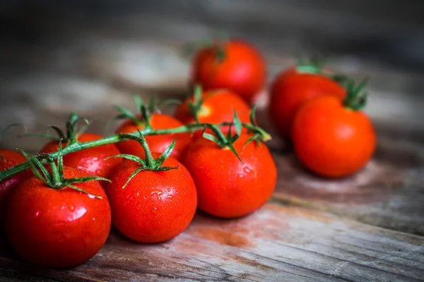 Tomates sobre fondo rústico de madera — Foto de Stock