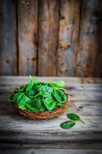 Spinaci freschi su fondo rustico in legno — Foto Stock