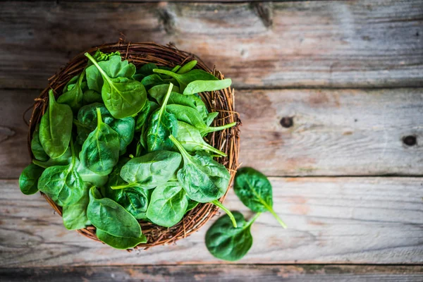 Spinaci freschi su fondo rustico in legno — Foto Stock