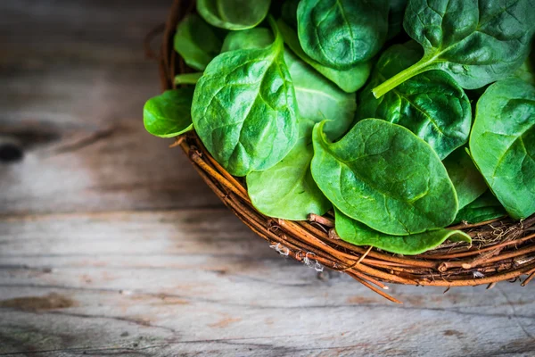 Spinaci freschi su fondo rustico in legno — Foto Stock