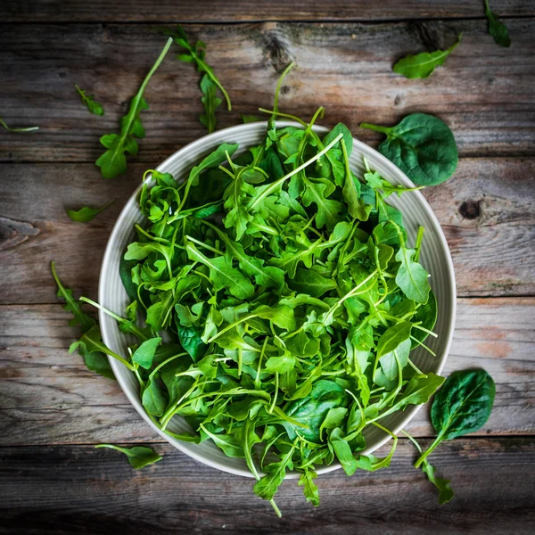 Rucola fresca e insalata di spinaci su sfondo rustico — Foto Stock