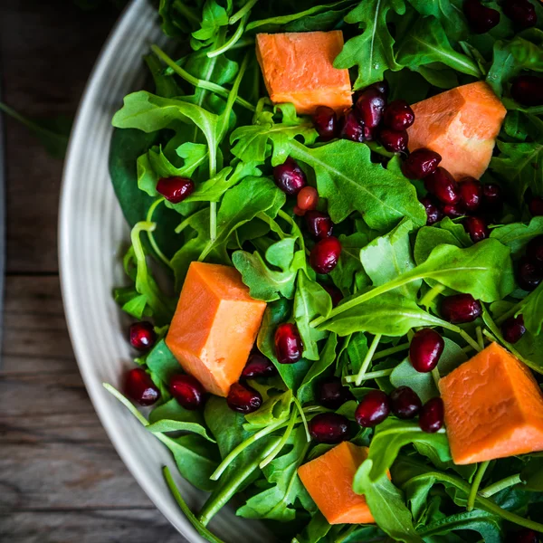 Verse rucola en spinazie salade met pompoen op rustieke pagina — Stockfoto