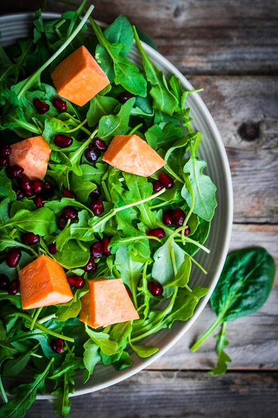 Frischer Rucola-Spinat-Salat mit Kürbis auf rustikalem Hintergrund — Stockfoto