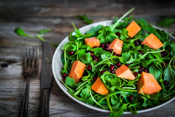 Frischer Rucola-Spinat-Salat mit Kürbis auf rustikalem Hintergrund — Stockfoto