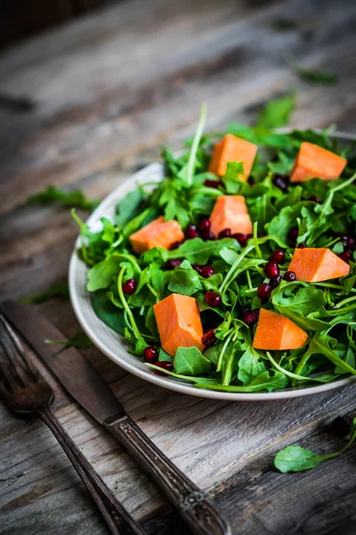 Salade de roquette fraîche et d'épinards à la citrouille sur fond rustique — Photo