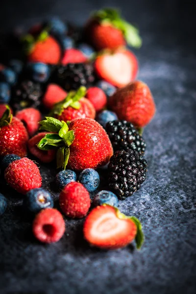 Смесь ягод на деревенском черном фоне — стоковое фото