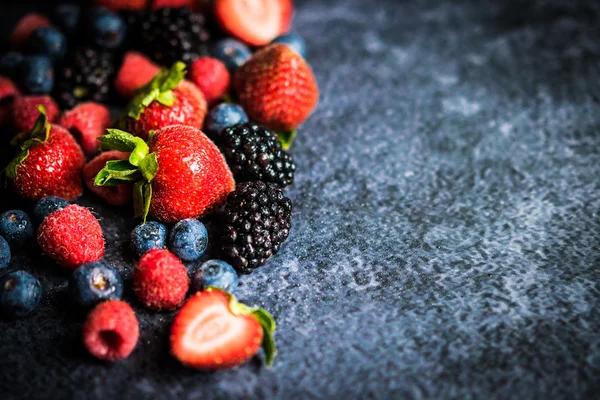 Berry mix on rustic black background — Stock Photo, Image