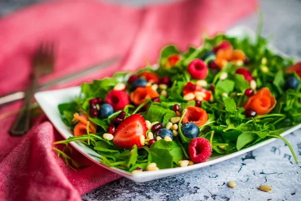 Здоровый салат с рукколой, шпинатом, копченым лососем и ягодами — стоковое фото