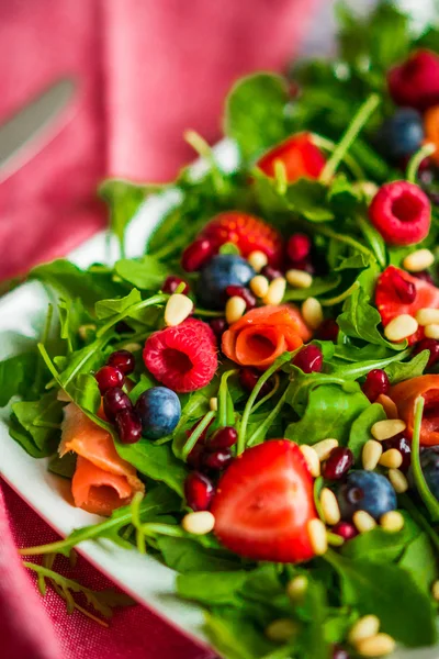 Здоровий салат з руколою, шпинатом, копченим лососем та ягодами — стокове фото