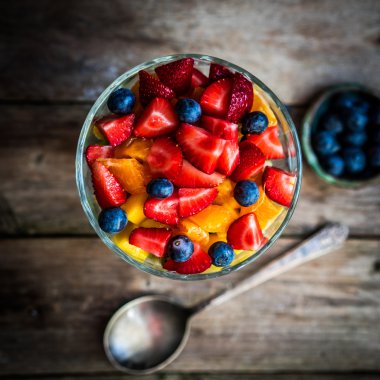 Bir kavanoza rustik ahşap arka plan üzerinde renkli meyve salatası