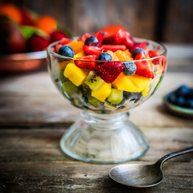 Bir kavanoza rustik ahşap arka plan üzerinde renkli meyve salatası