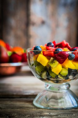 Bir kavanoza rustik ahşap arka plan üzerinde renkli meyve salatası