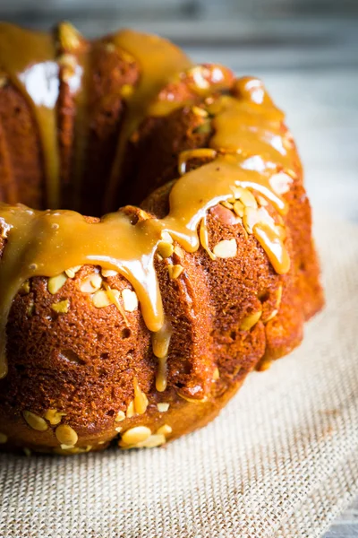 Pastel casero de otoño con semillas de calabaza y caramelo en ba de madera — Foto de Stock