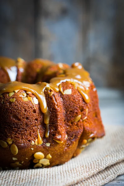 Pastel casero de otoño con semillas de calabaza y caramelo en ba de madera — Foto de Stock