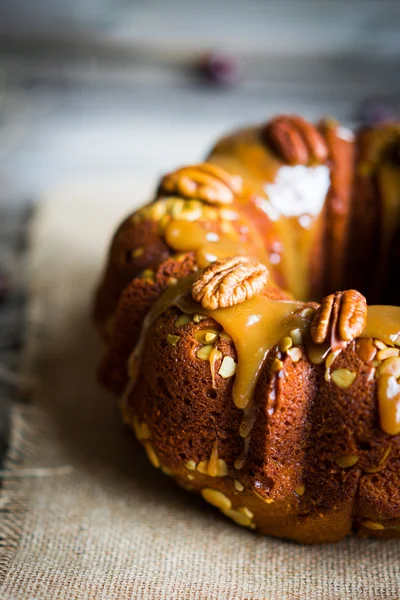 Pastel casero de otoño con nueces y caramelo sobre fondo de madera — Foto de Stock