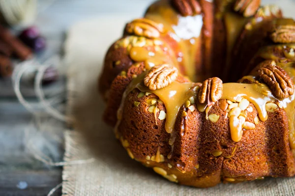 Pastel casero de otoño con nueces y caramelo sobre fondo de madera — Foto de Stock