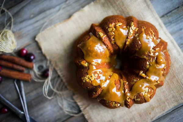 Pastel casero de otoño con semillas de calabaza y caramelo en ba de madera — Foto de Stock