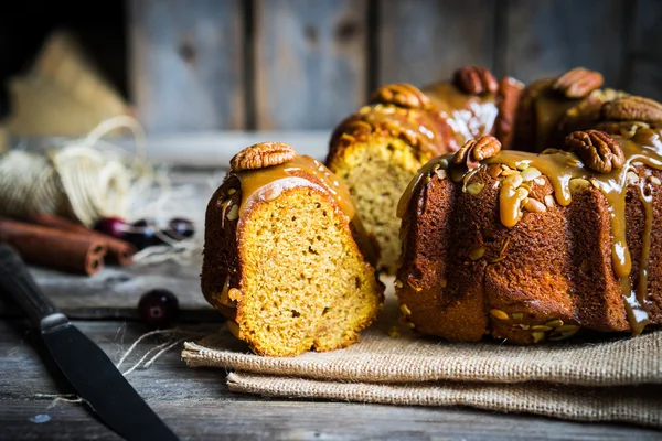 Домашний осенний торт с орехами и карамелью на деревянном фоне — стоковое фото