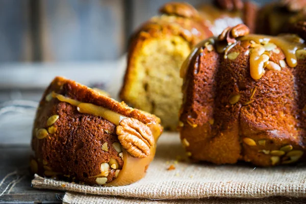 Pastel casero de otoño con nueces y caramelo sobre fondo de madera — Foto de Stock