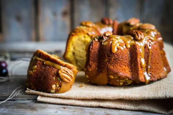 Pastel casero de otoño con nueces y caramelo sobre fondo de madera — Foto de Stock