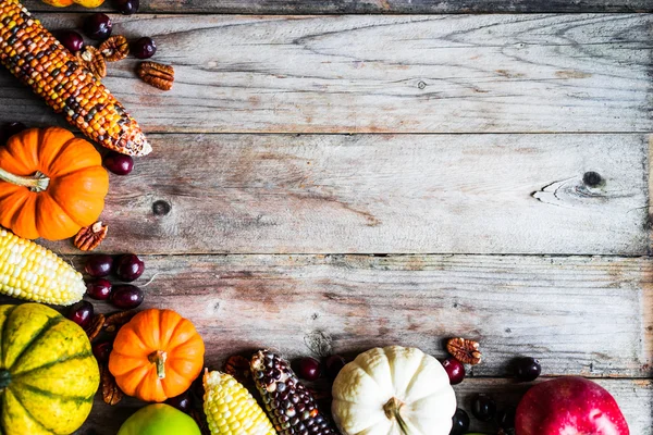 Calabazas, maíz, manzanas, nueces y arándanos sobre fondo de madera — Foto de Stock