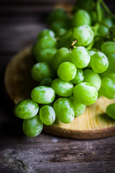 Vine of green grapes on rustic wooden background — Stock Photo, Image