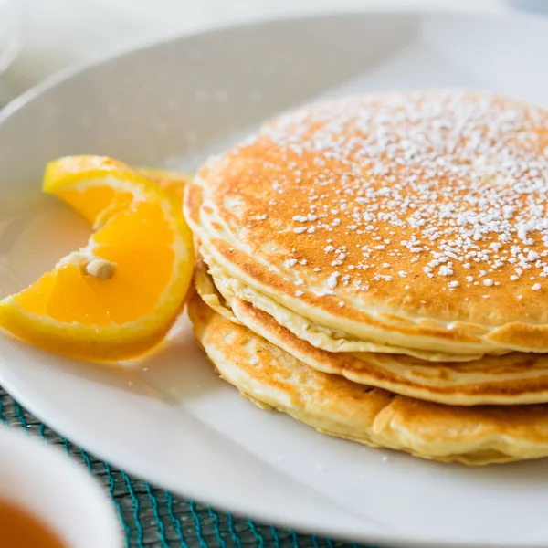 Pancakes with sugar powder on white plate — Stock Photo, Image