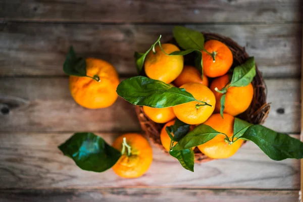 Mandarinas con hojas sobre fondo de madera —  Fotos de Stock