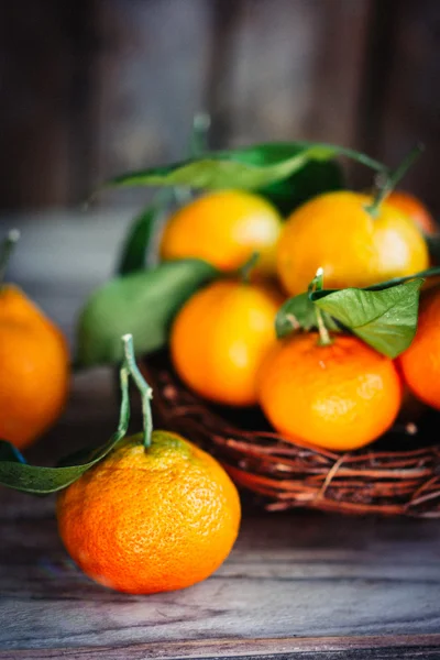 Tangerines with leaves on wooden background — Stock Photo, Image