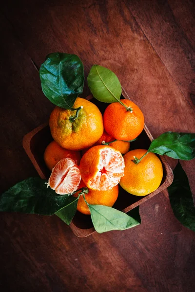 Tangeriner med blad på trä bakgrund — Stockfoto