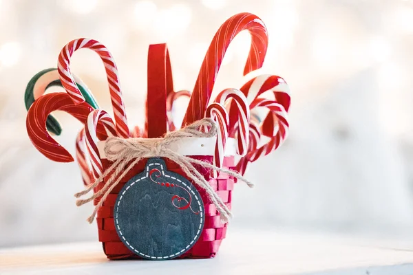 Bastones de caramelo en una canasta sobre fondo navideño —  Fotos de Stock