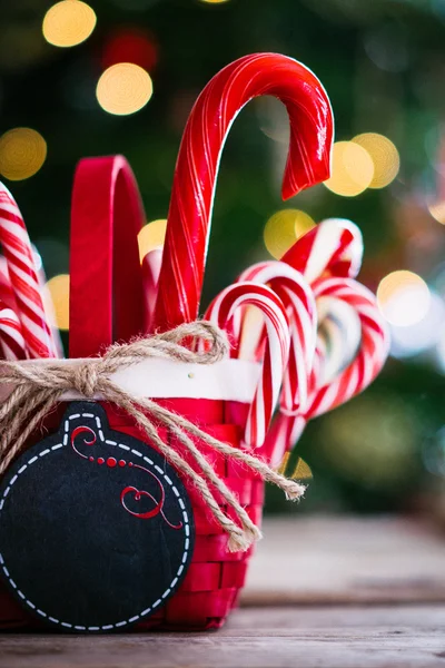 Baston şekerler Noel arka plan üzerinde bir sepet içinde — Stok fotoğraf