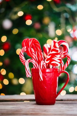 Baston şekerler ahşap arka plan üzerinde kırmızı kupa