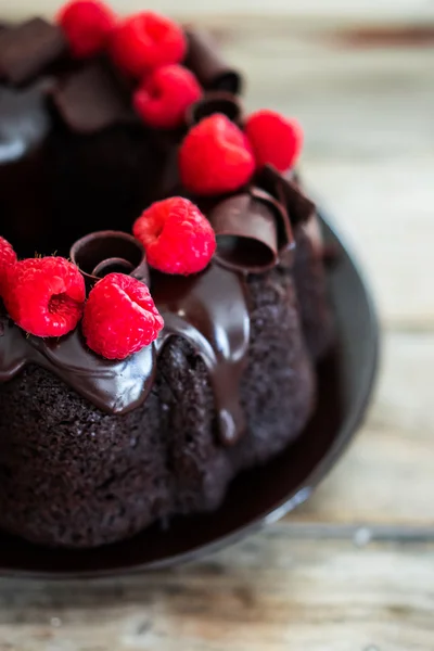 Bolo de chocolate com framboesas em fundo de madeira rústica — Fotografia de Stock