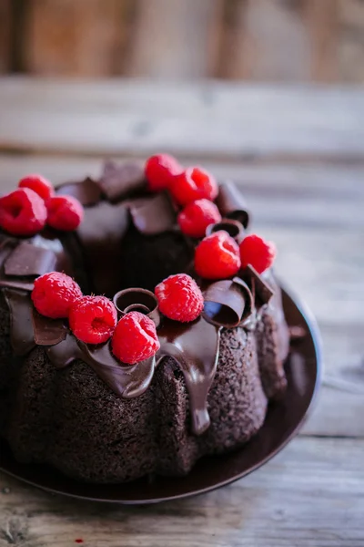 Chocolate cake met frambozen op rustieke houten achtergrond — Stockfoto