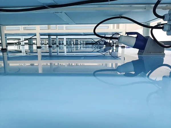 Deniz mavisi epoksi zemininde, askıların altında bir kablo. Endüstriyel epoksi zemin)