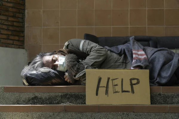 ホームレスの男が道路の脇で寝ている — ストック写真